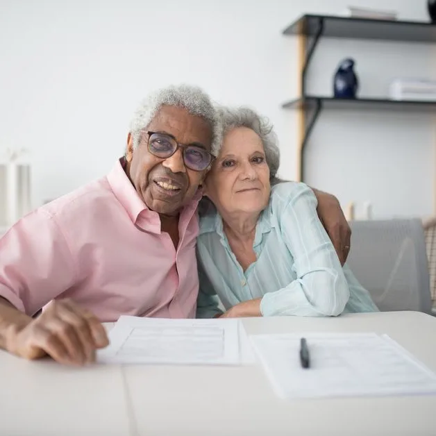 Couple de retraités relisant des documents à la table